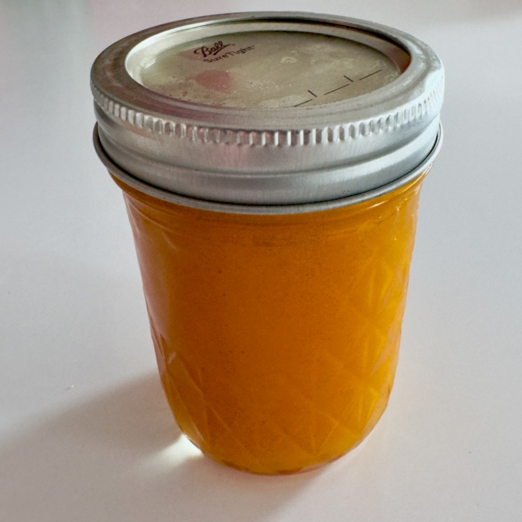 A mason jar filled with passion fruit coulis.